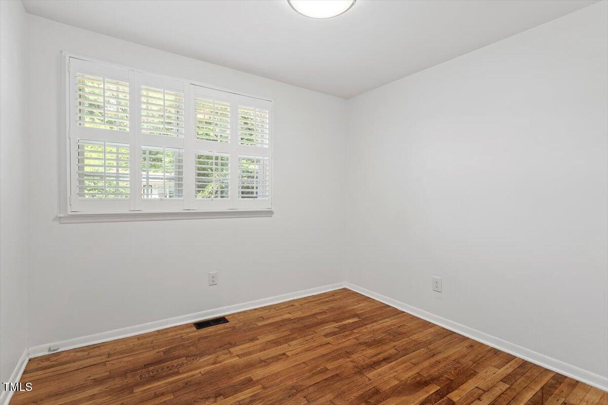 1621 Seminole Trail Raleigh, NC 27609 - Photo 19 of 25 an empty room with wooden floor and windows