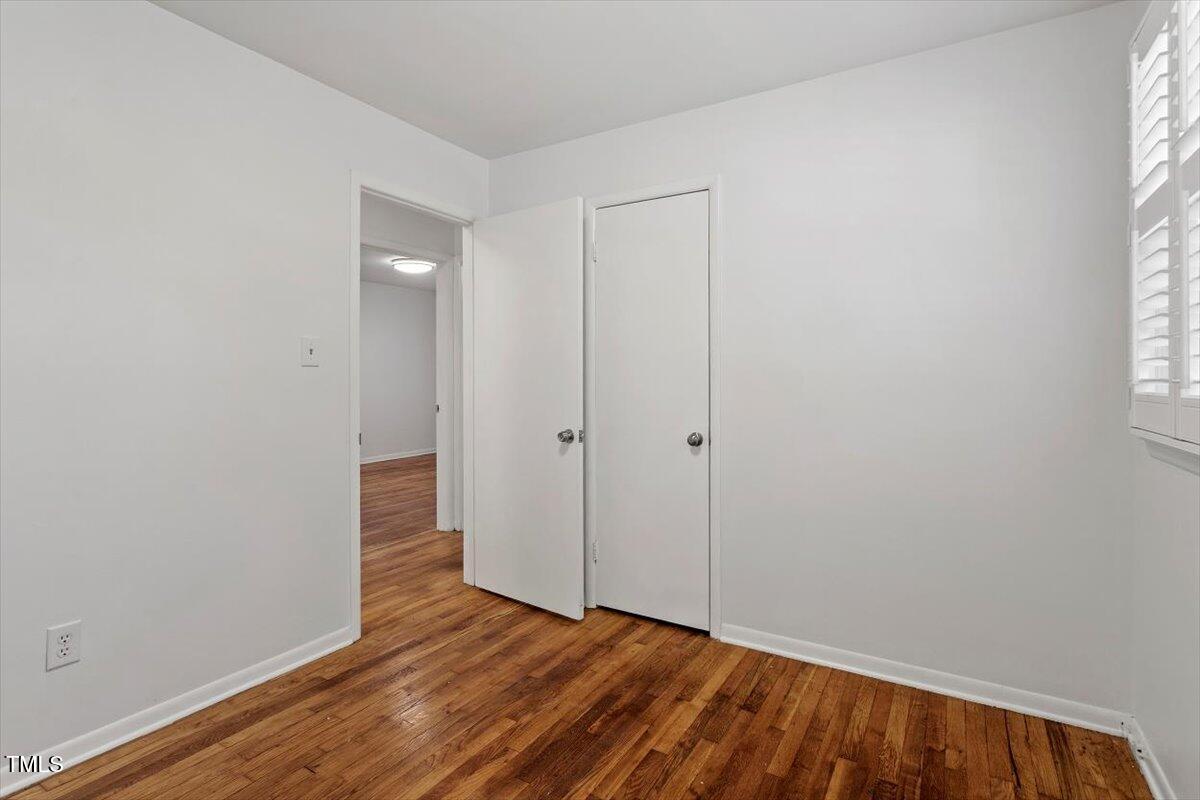 1621 Seminole Trail Raleigh, NC 27609 - Photo 20 of 25 a view of an empty room with wooden floor and a window
