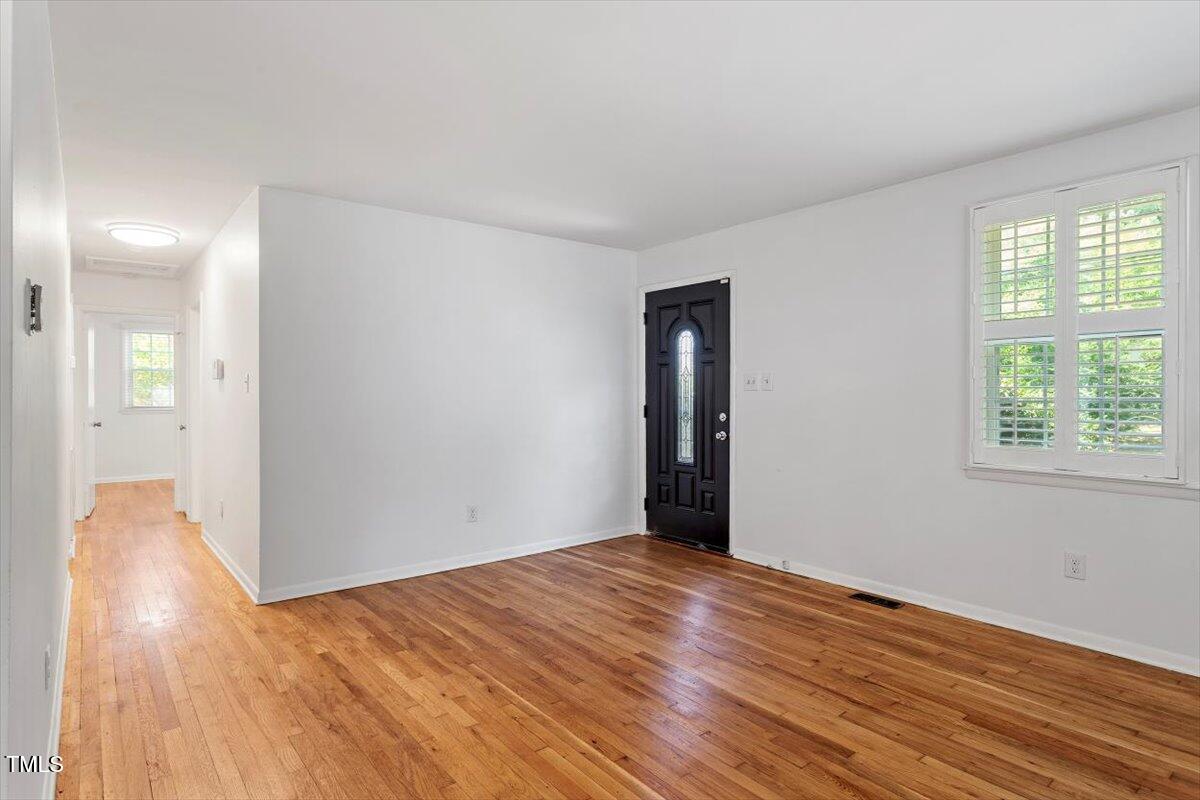 1621 Seminole Trail Raleigh, NC 27609 - Photo 5 of 25 an empty room with wooden floor and windows