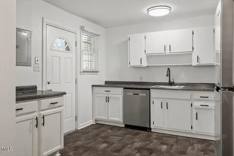 a kitchen with granite countertop white cabinets white stainless steel appliances with a sink and dishwasher