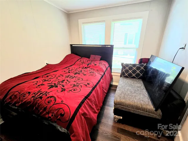 a bed sitting in a bedroom next to a window with yard