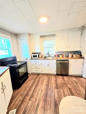 a kitchen with a sink a stove top oven and cabinetry