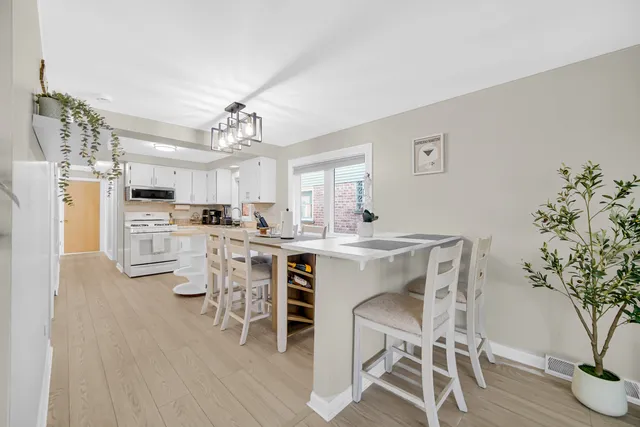 a view of a dining room with furniture a chandelier and wooden floor