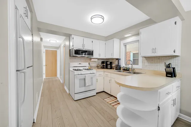 a kitchen with stainless steel appliances granite countertop a sink stove and cabinets