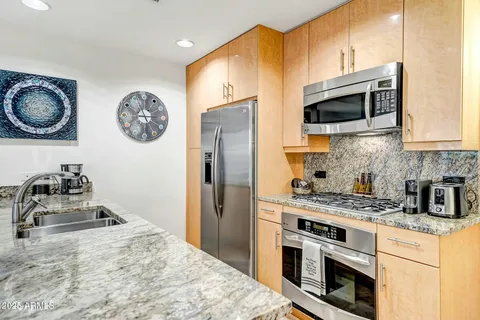 a kitchen with stainless steel appliances granite countertop a stove and a microwave