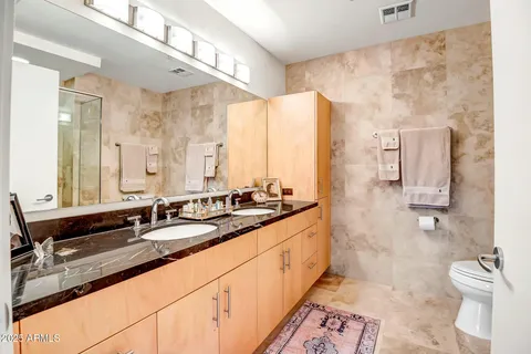 a bathroom with double sink and a mirror