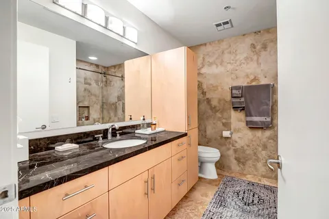 a bathroom with a granite countertop sink toilet and shower
