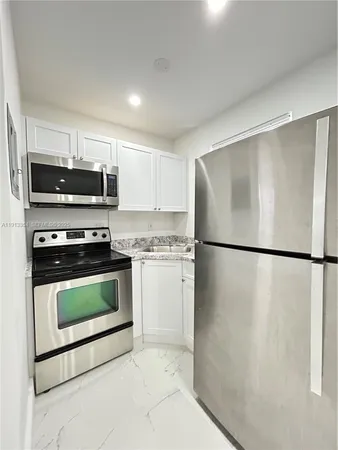 a kitchen with a refrigerator and a stove top oven