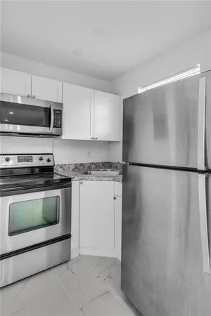 a kitchen with a refrigerator and a stove top oven
