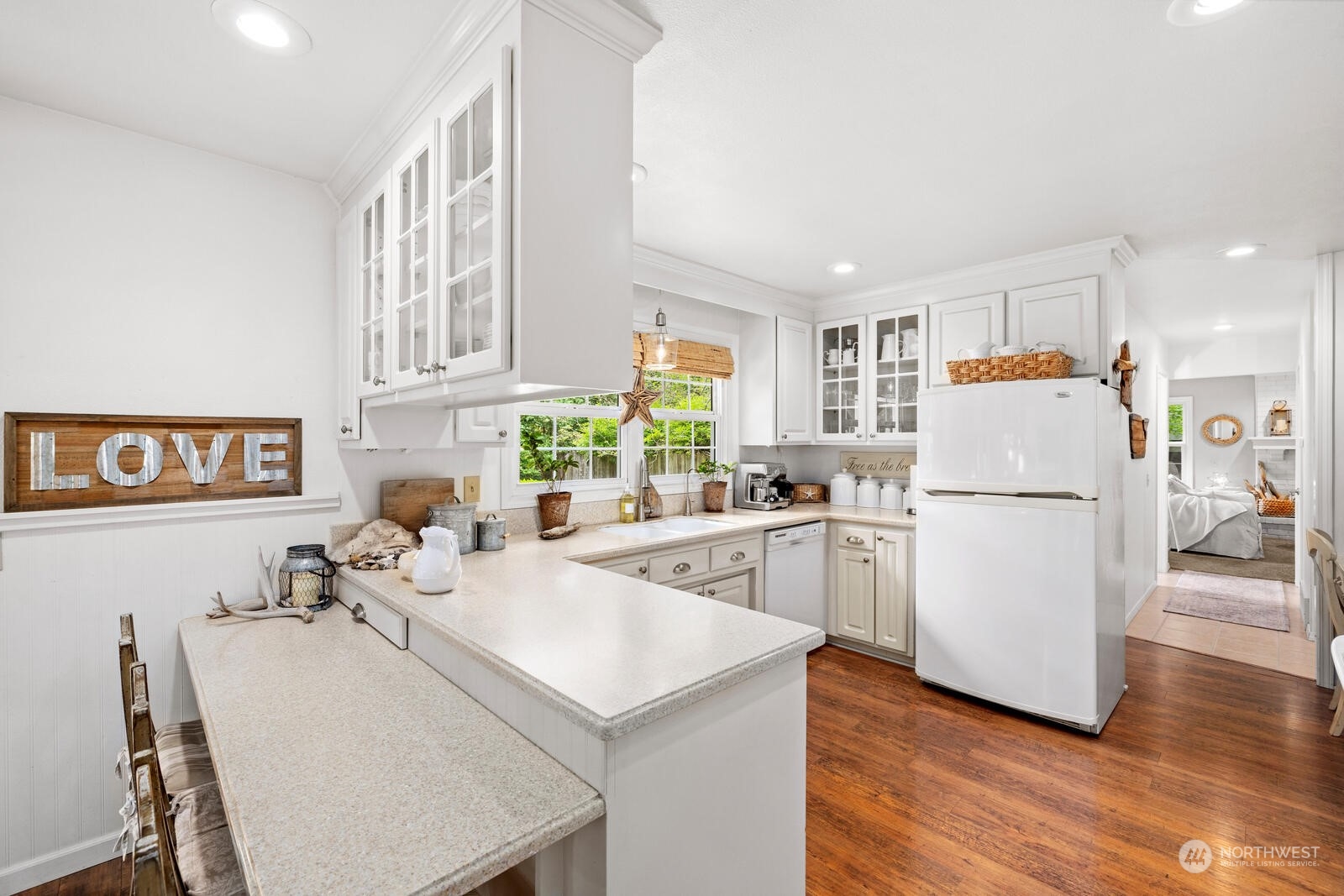 525 192nd Place Southeast Bothell, WA 98012 - Photo 10 of 40 a kitchen with a sink a stove a refrigerator and white cabinets with wooden floor