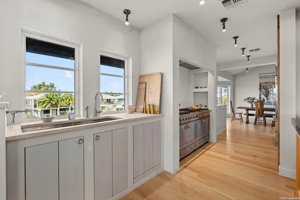 a kitchen with stainless steel appliances a stove a sink dishwasher and cabinets with wooden floor