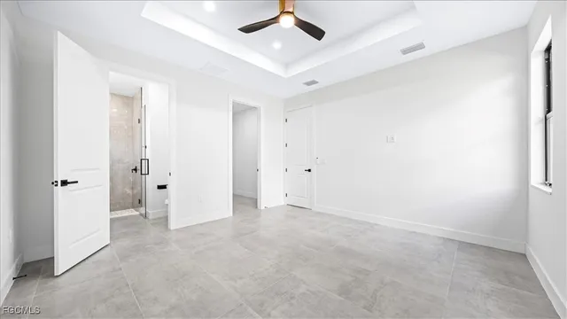 an empty room with closet and a ceiling fan