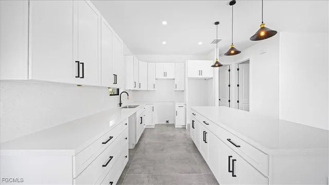 a large white kitchen with stainless steel appliances