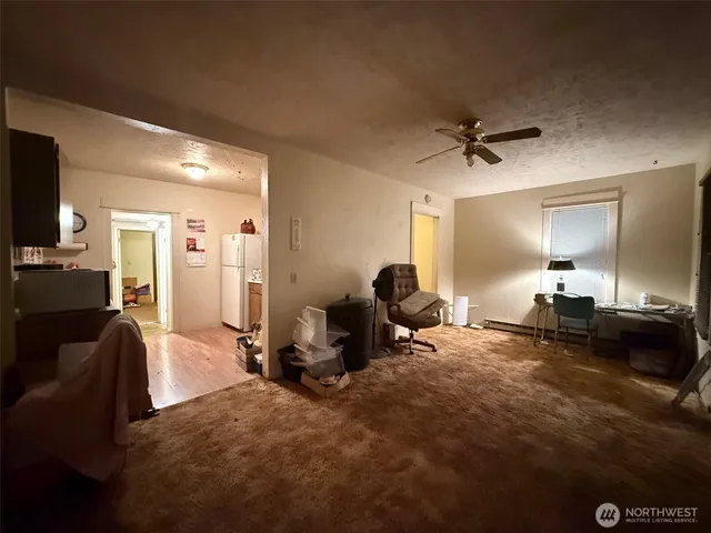 a living room with furniture a flat screen tv and gym equipment