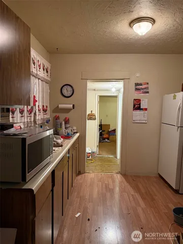 a kitchen with stainless steel appliances a refrigerator a stove a sink dishwasher and wooden floor