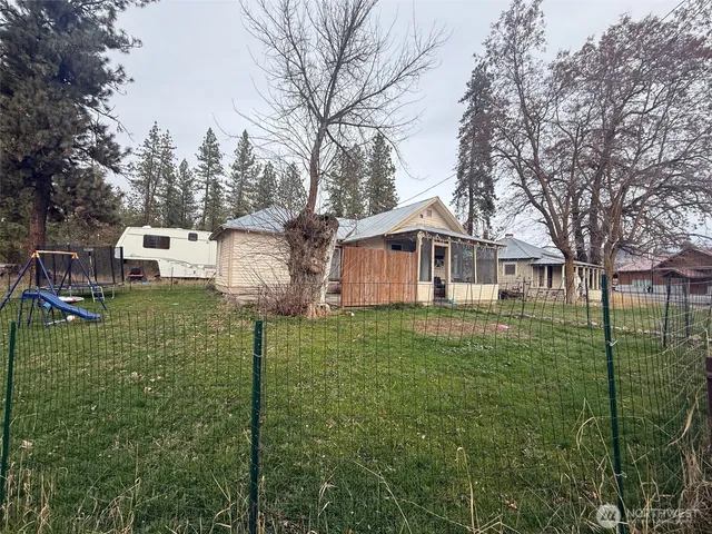 a front view of a house with a garden and trees