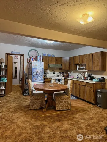 a living room with stainless steel appliances kitchen island granite countertop a stove and a sink