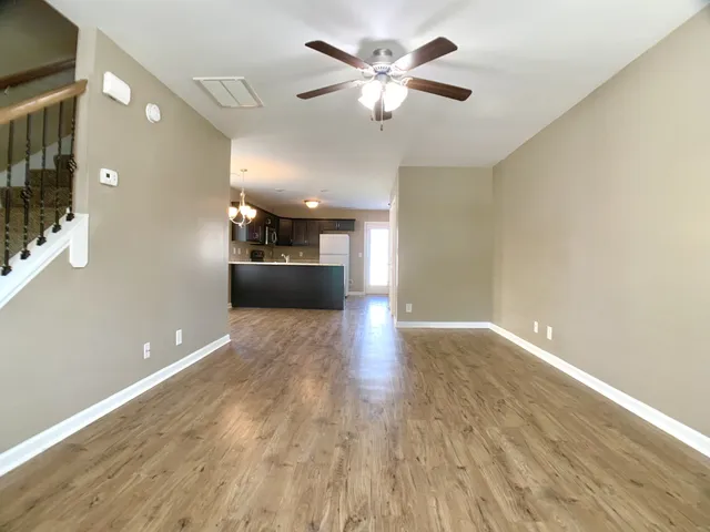 a view of a big room with wooden floor and a ceiling fan
