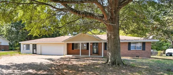 a front view of a house with a garden and yard
