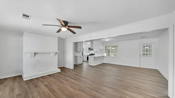 a view of a kitchen with wooden floor and a ceiling fan
