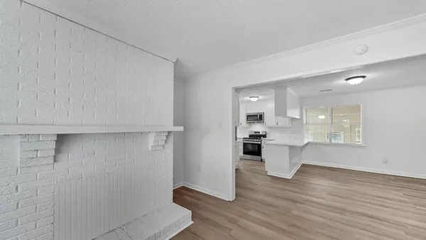 a view of kitchen with white cabinets and wooden floor
