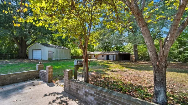 a view of a house with backyard and a tree