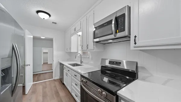 a kitchen with stainless steel appliances granite countertop a stove a refrigerator and a microwave