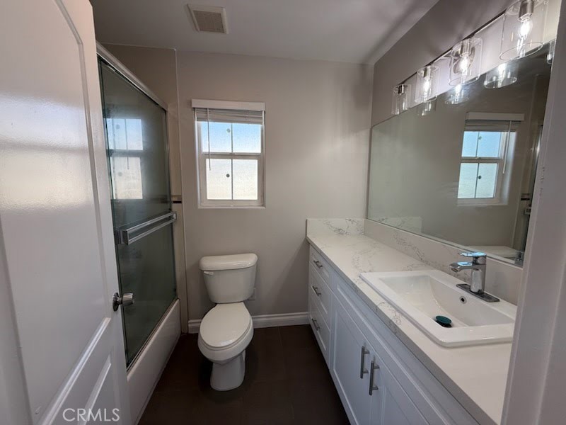 8724 Ramona Street, Unit 4 Bellflower, CA 90706 - Photo 5 of 7 a bathroom with a toilet sink and mirror