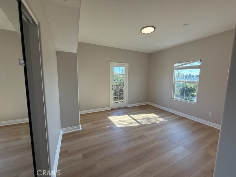 8724 Ramona Street, Unit 4 Bellflower, CA 90706 - Photo 6 of 7 an empty room with wooden floor and windows