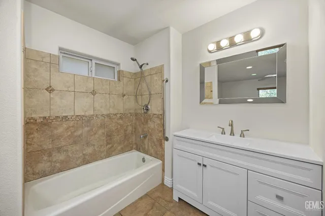 a bathroom with a tub a sink and mirror