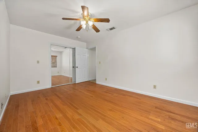 a view of empty room with wooden floor