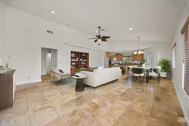 a living room with furniture a dining table and chairs with kitchen view