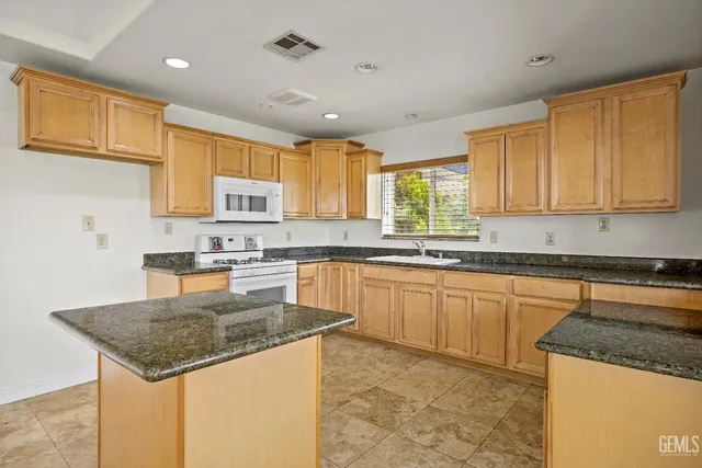 a kitchen with stainless steel appliances granite countertop a sink stove and microwave