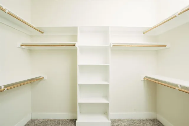 a view of walk in closet with empty racks