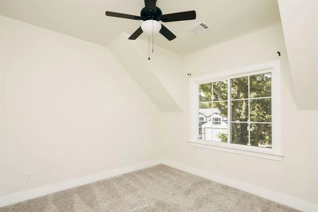 an empty room with a window and a fan
