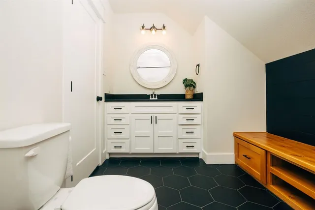 a bathroom with a toilet a sink and mirror