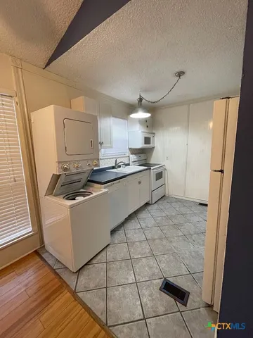 a kitchen with kitchen island a counter top space a sink a refrigerator and cabinets