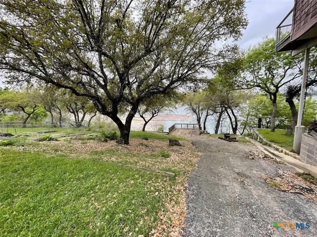 a view of dirt yard with a tree