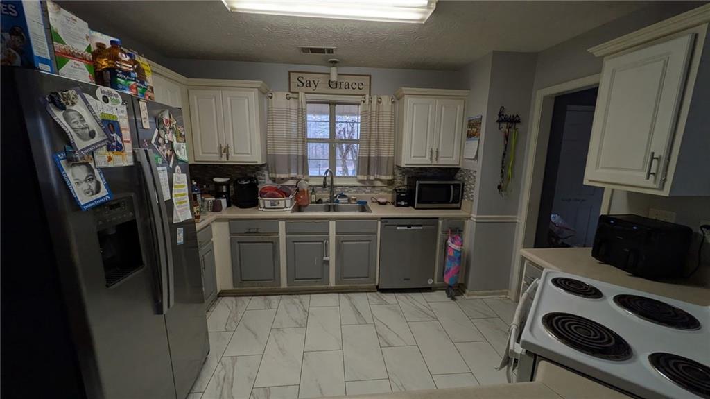 230 Overlook Drive Covington, GA 30016 - Photo 23 of 34 a kitchen with stainless steel appliances a stove a sink and a refrigerator