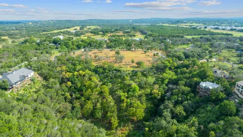 an aerial view of residential houses with outdoor space and trees