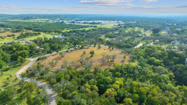 an aerial view of residential houses with outdoor space and trees