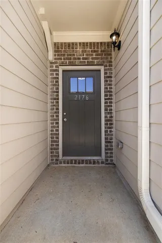 a view of an empty room with wooden floor fireplace and a window