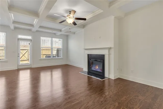 a view of a livingroom with wooden floor and a ceiling fan