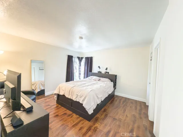 a bedroom with a bed and wooden floor