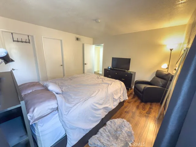 a bedroom with a bed and wooden floor
