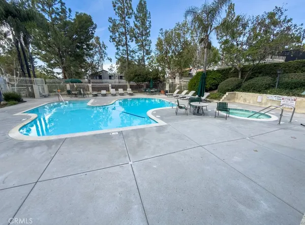 a view of backyard with swimming pool and seating space