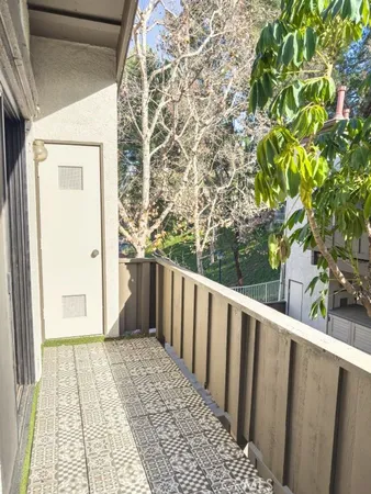 a view of a balcony with wooden floor and fence