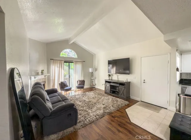 a living room with furniture a flat screen tv and a fireplace
