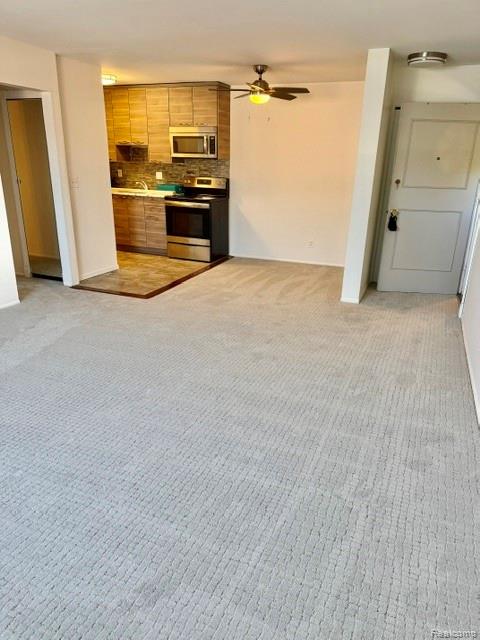 805 Plate Street, Unit 210 Rochester, MI 48307 - Photo 8 of 20 Kitchen with stainless steel appliances, tasteful backsplash, a ceiling fan, and light colored carpet