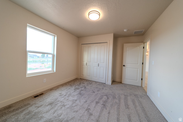 130 Pole Line Road, Unit 2 Roosevelt, UT 84066 - Photo 26 of 33 Carpeted room featuring a double-pane window, bi-fold closet doors, a paneled interior door, recessed lighting, and neutral wall tones